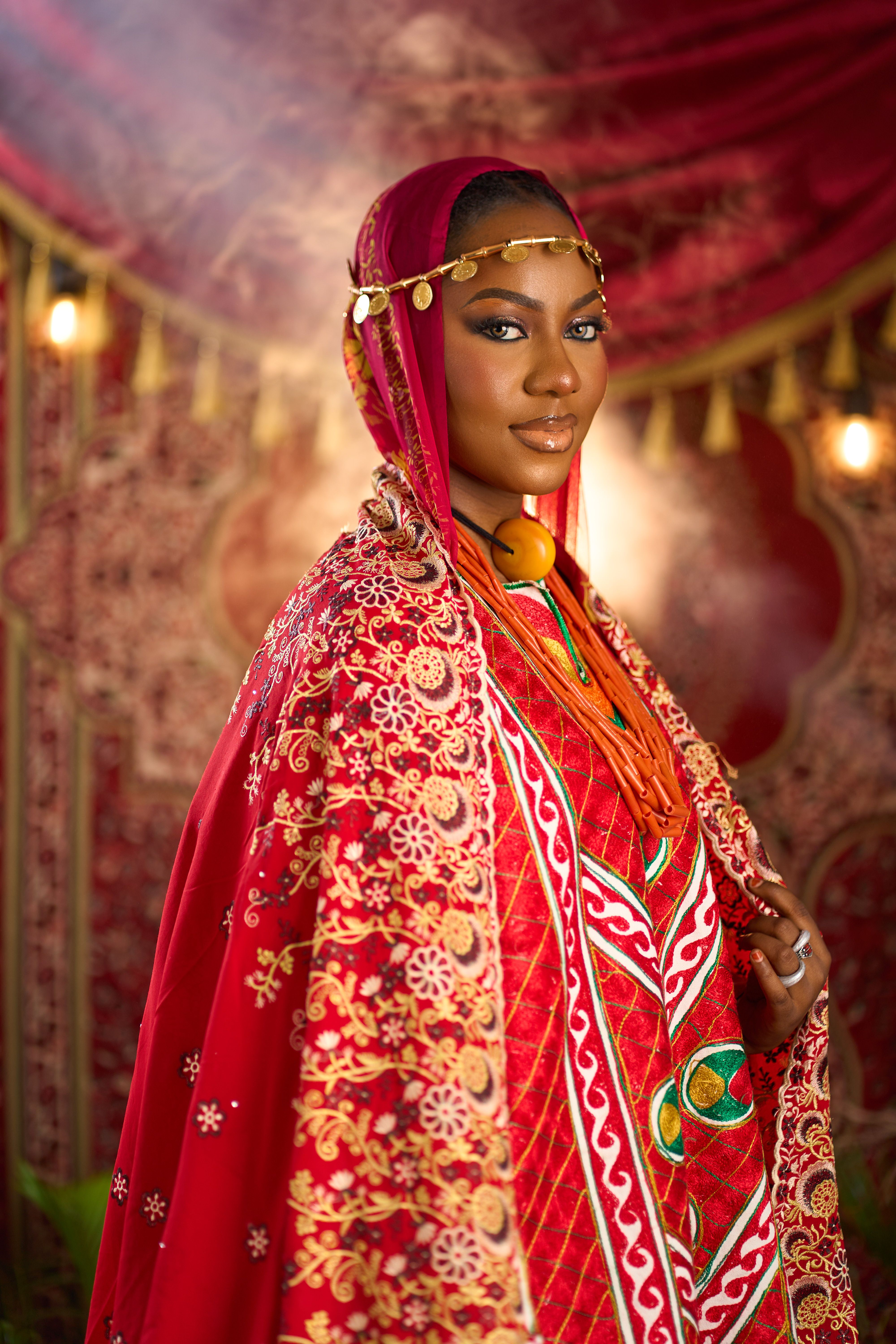 Beautiful portrait of a woman wearing intricate traditional Nigerian attire with vibrant colors and detailed embroidery.