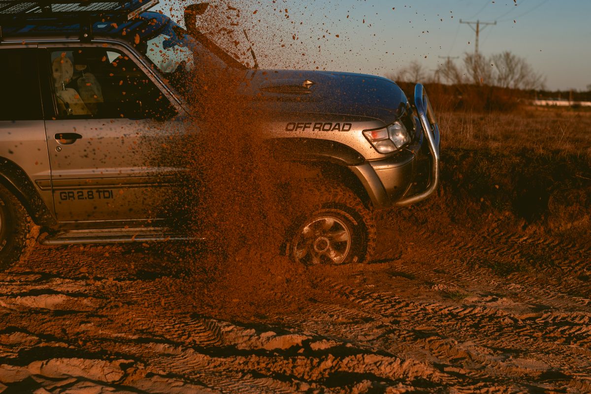 Off-road pickup truck loaded with recovery gear on a wooded trail