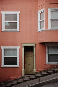 在加利福尼亚州旧金山，一座建筑立面充满活力的桃子色，配有一扇木制门