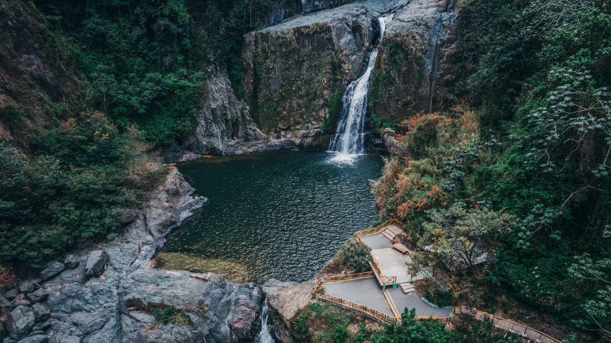 A breathtaking aerial view of a waterfall and forest pool in Jarabacoa, Dominican Republic