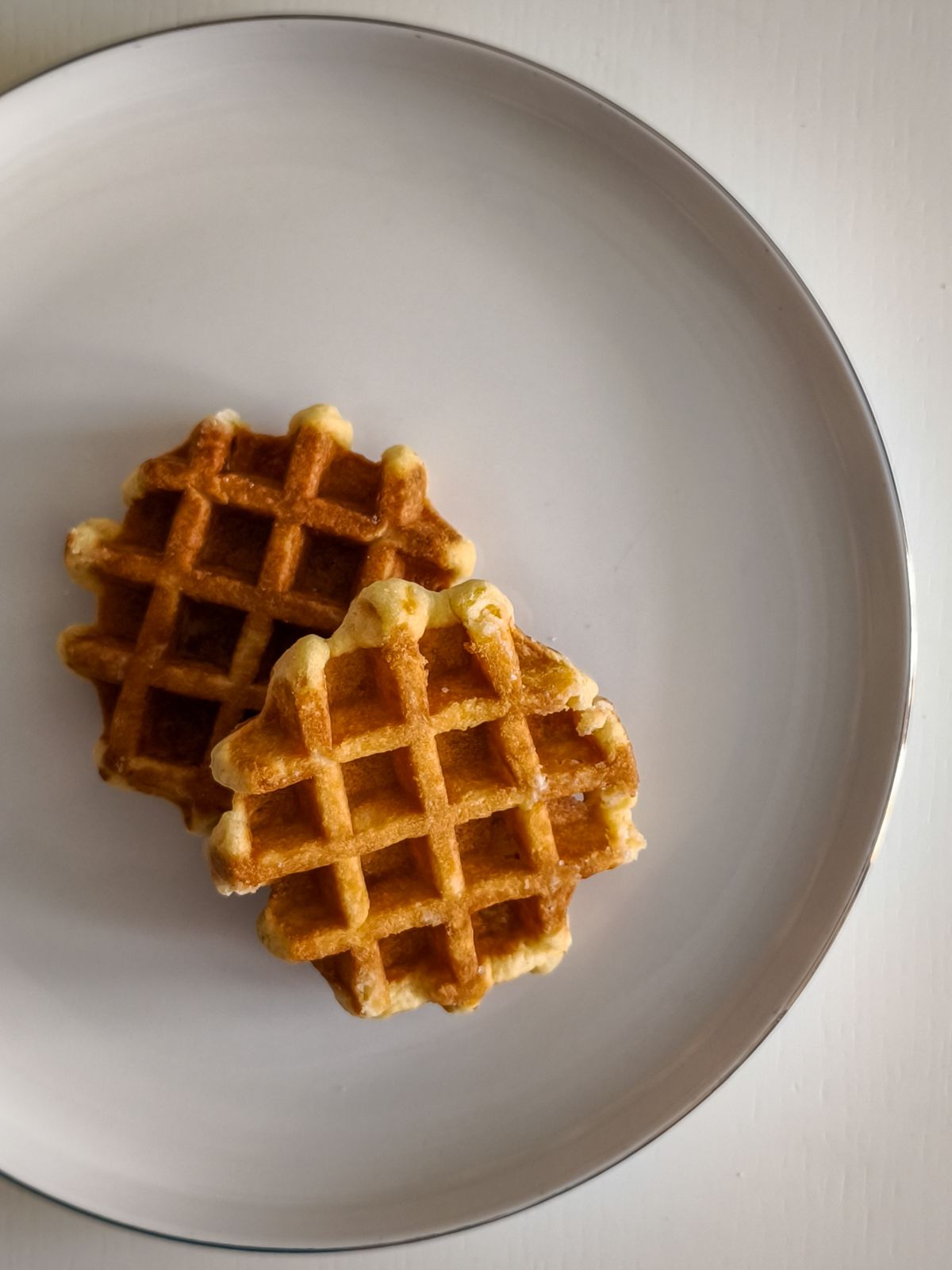 Two thick Belgian waffles on a white plate