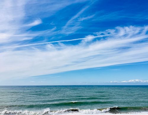 Free Tranquil ocean scene capturing waves and a clear blue sky, perfect for relaxation themes. Stock Photo