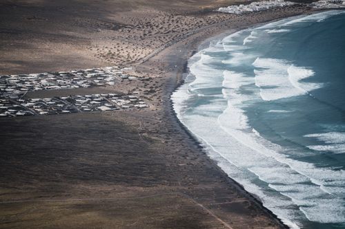 Free A stunning aerial capture of Lanzarote's rugged coastline and tranquil beach in Canarias, Spain. Stock Photo