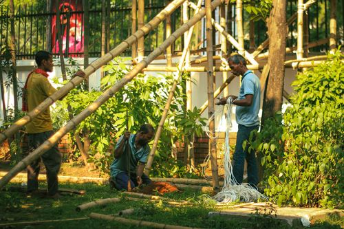 Free Workers in Dhaka assembling a bamboo structure, preparing for a New Year event. Stock Photo
