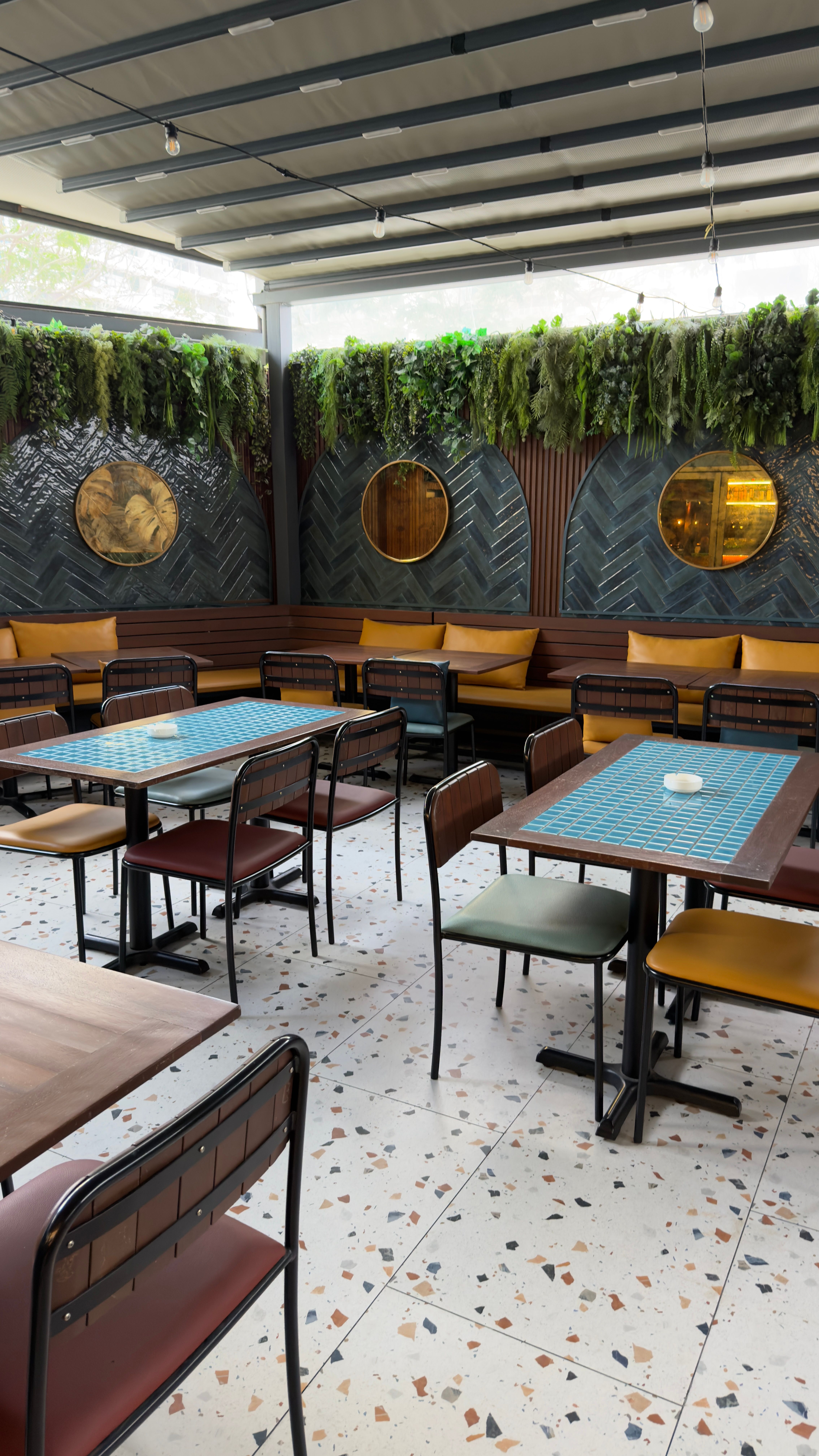 Stylish outdoor seating area with foliage and modern decor creating a serene dining environment.