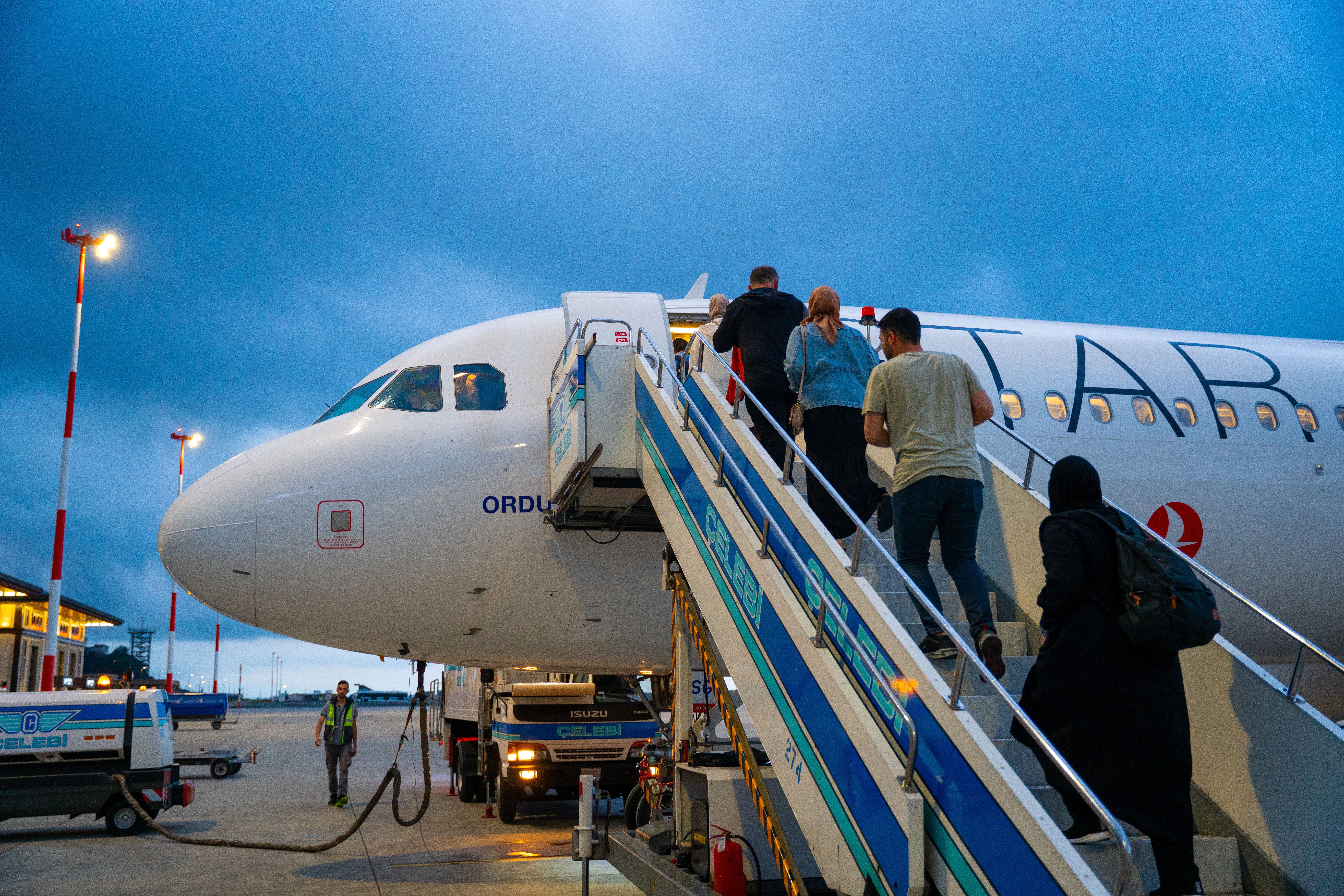 Travelers boarding plane at Rize Airport in Türkiye, showcasing modern air travel.