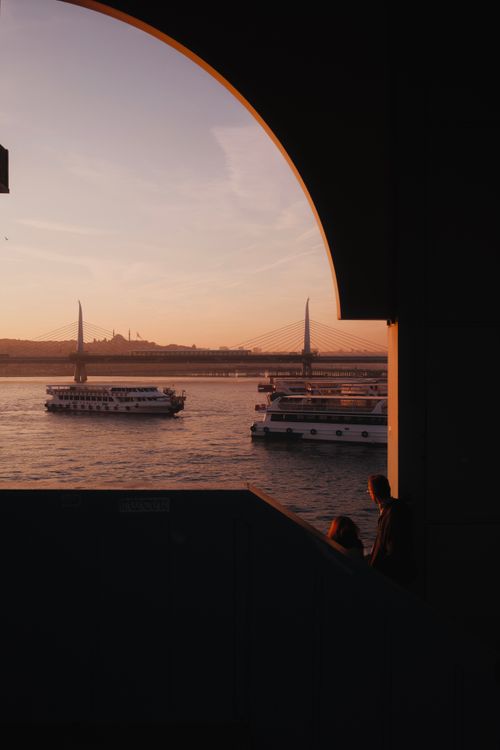 Free Silhouettes against the Bosphorus at sunset with ferries and a bridge in the background, captured in Istanbul, Turkey. Stock Photo