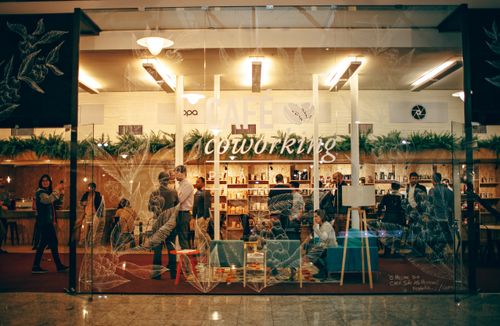Free A cozy and bustling indoor coworking space with people engaged in work and conversation. Stock Photo