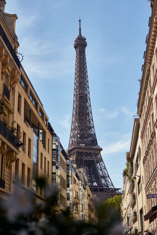 Free Captivating view of the Eiffel Tower surrounded by classic Parisian buildings under a clear blue sky. Stock Photo