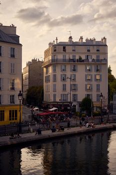 Beautiful view of a Parisian canal with scenic apartment buildings at sunset.