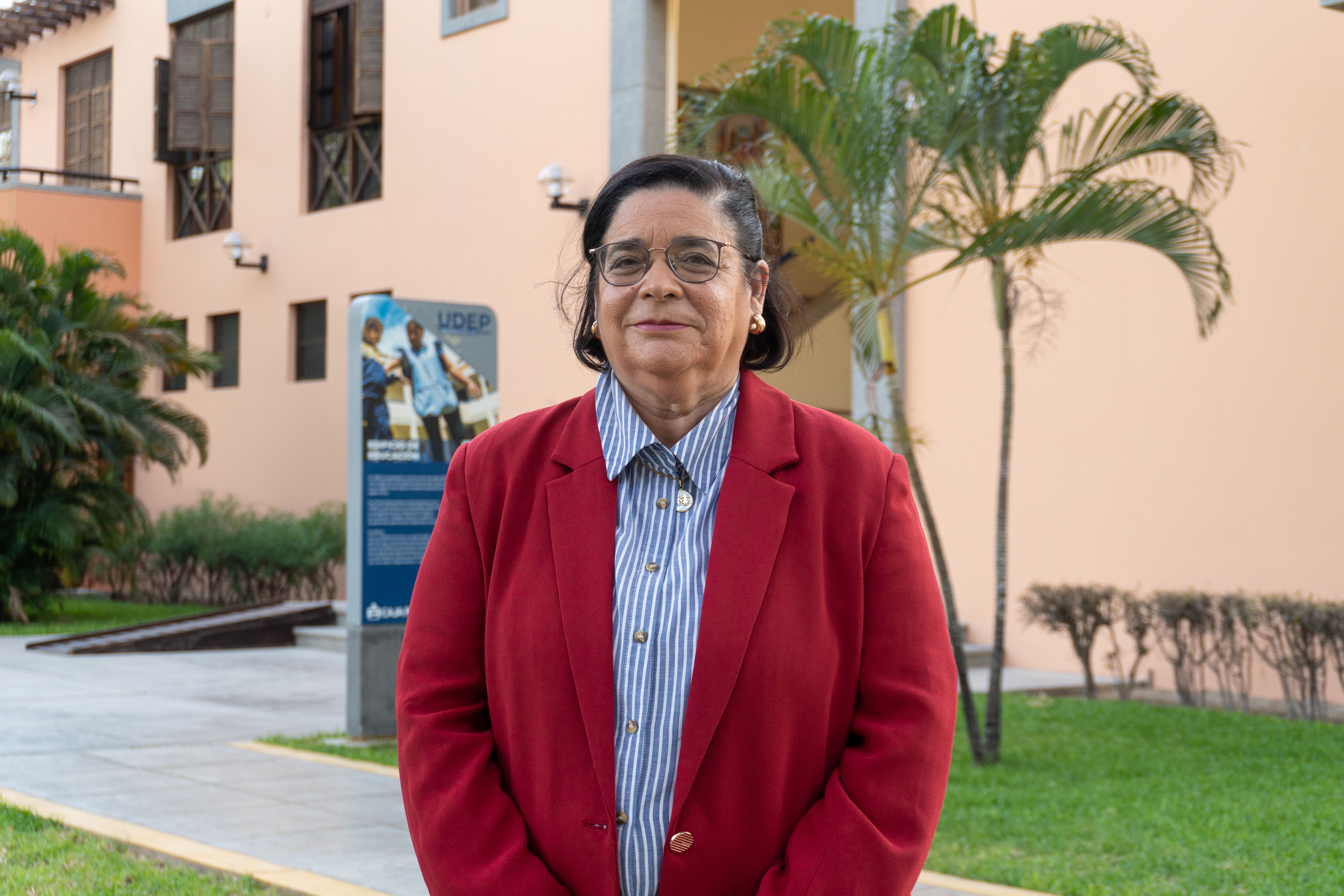 Confident woman in red blazer posing outdoors in Piura, Peru.