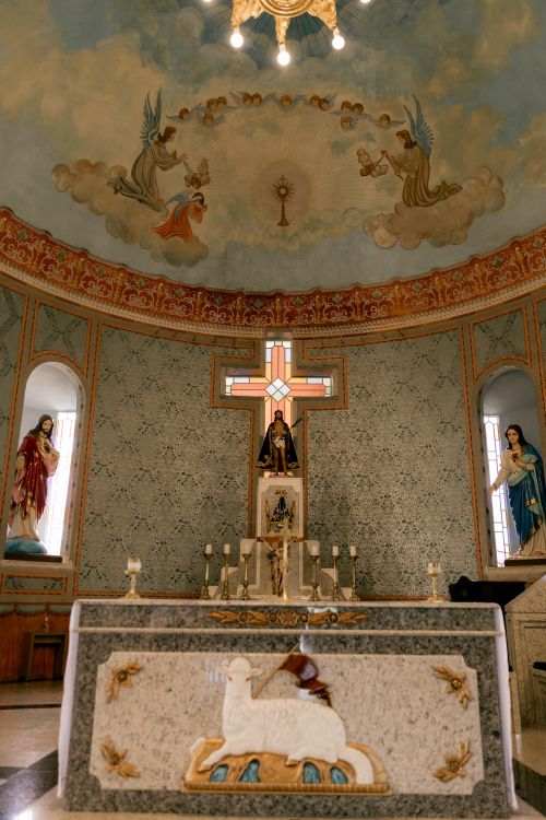 Free A beautifully decorated church altar with religious statues and a painted ceiling. Stock Photo