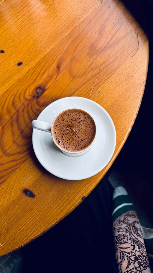 Free A cup of traditional Turkish coffee served on a rustic wooden table, creating a warm and cozy atmosphere. Stock Photo