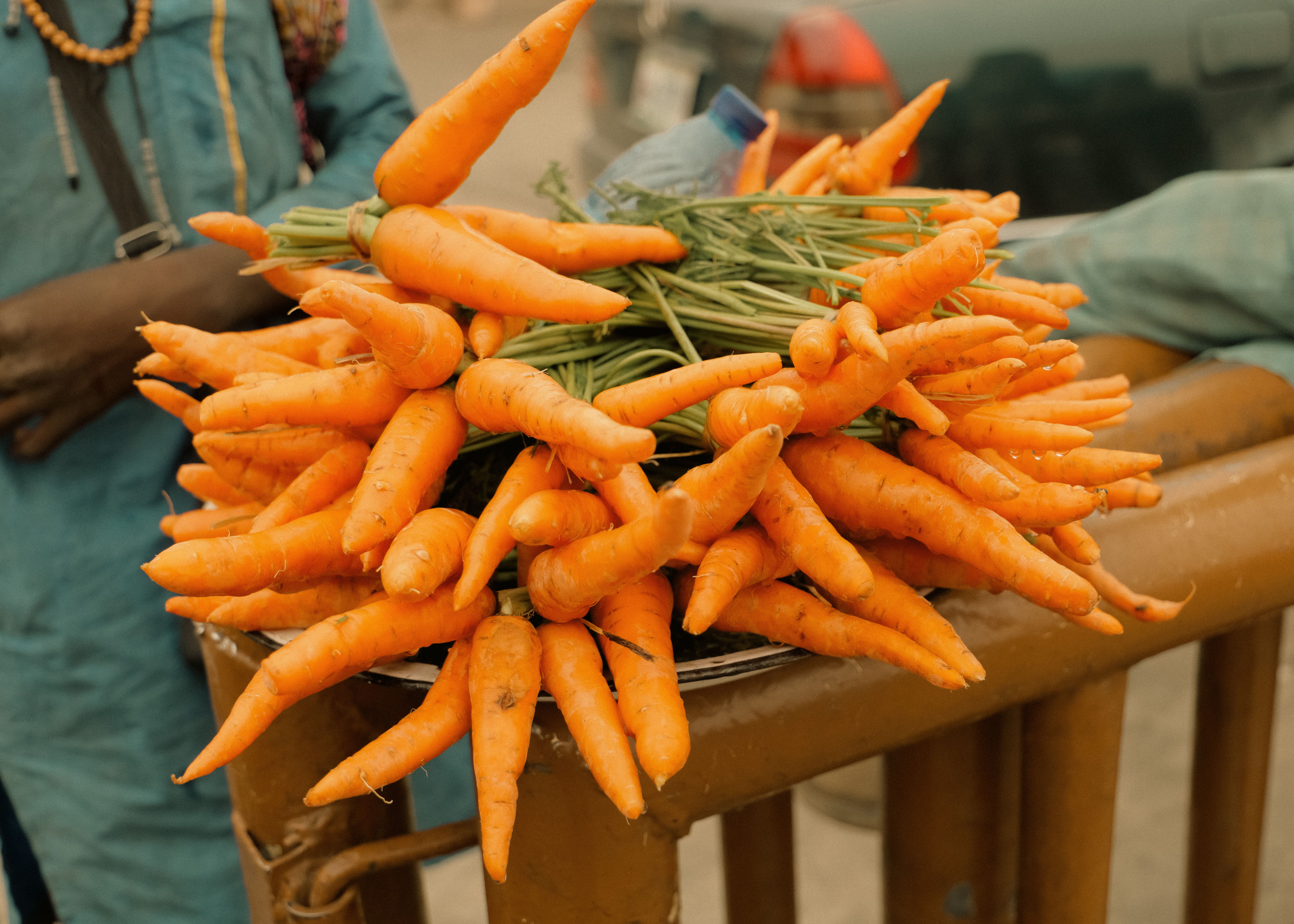 Vibrant bunches of fresh organic carrots displayed at an outdoor market, showcasing natural produce.