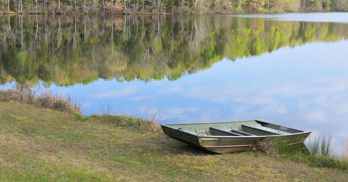 Peaceful spring morning view at Lancaster lake with a boat reflecting in the calm water.