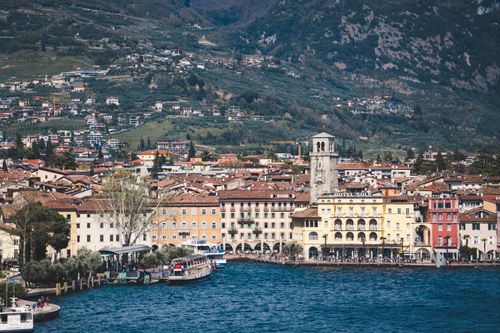 Free Picturesque view of Riva del Garda with colorful buildings and mountains by the lake shore. Stock Photo