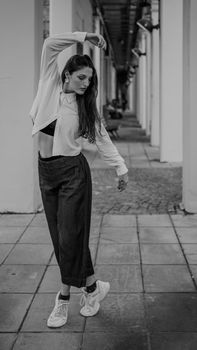A dancer poses gracefully in an architectural black and white setting.