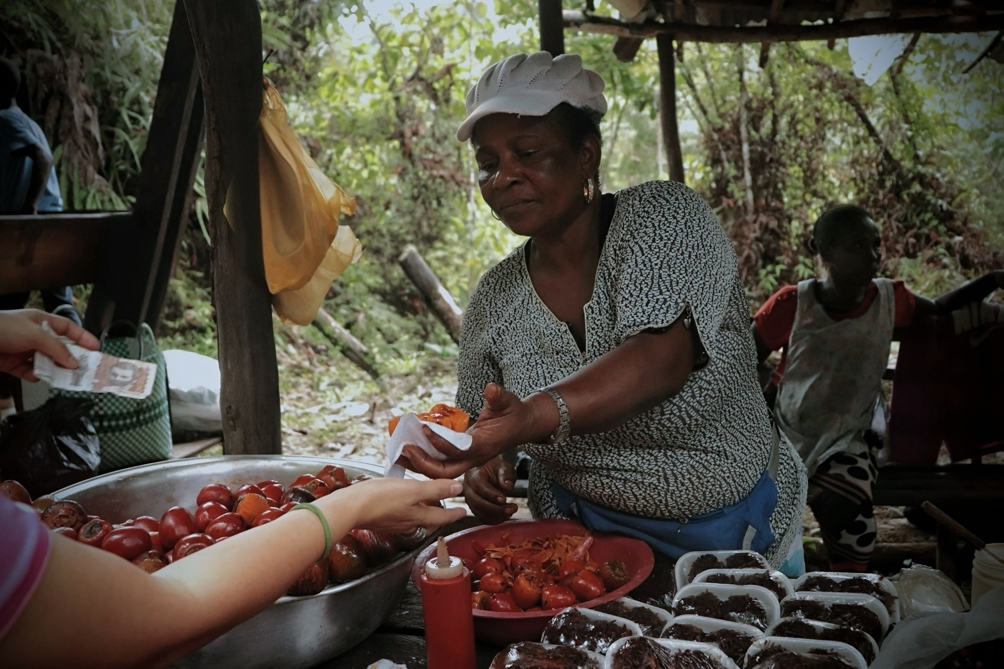 Hands exchanging small banknotes at a market stall in La Paz, Honduras
