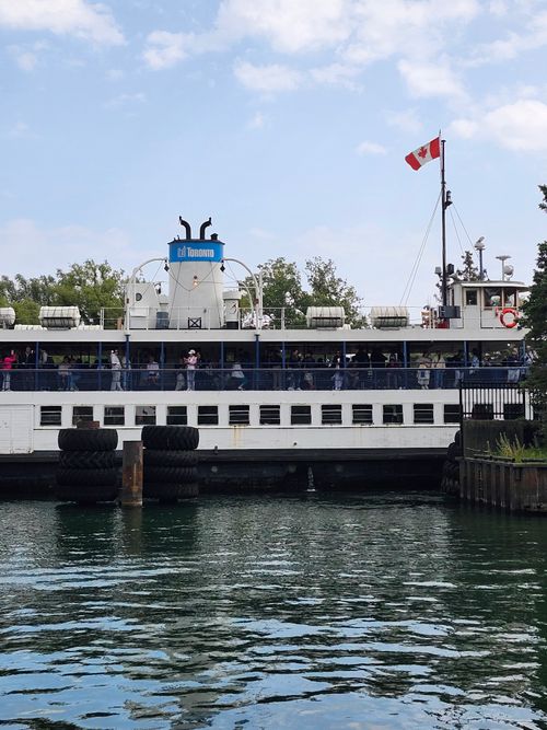 Free Toronto Island Ferry at the dock with clear skies and water reflection. Stock Photo