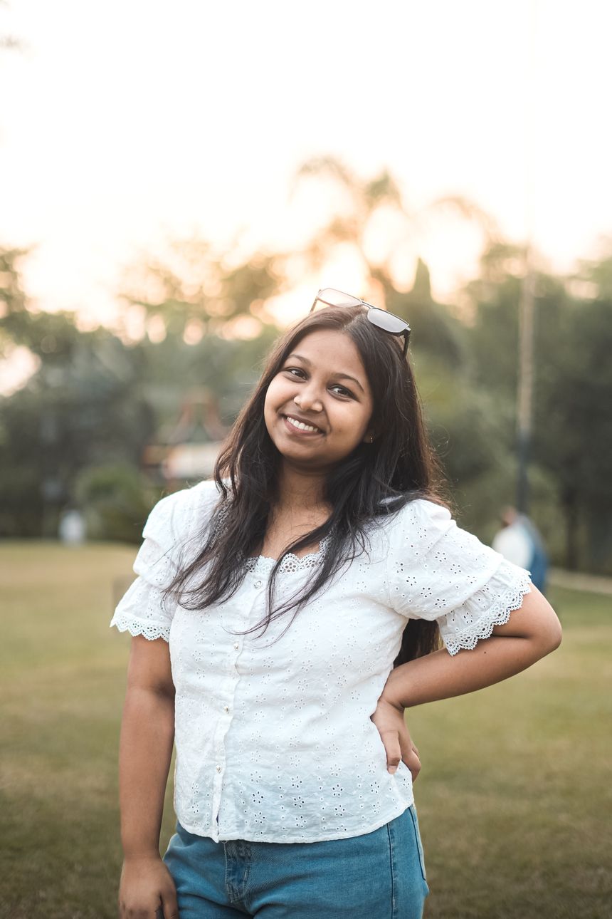 Speaker greeting the camera in a sunlit park — photo by NILU'Z FrameScape on Pexels