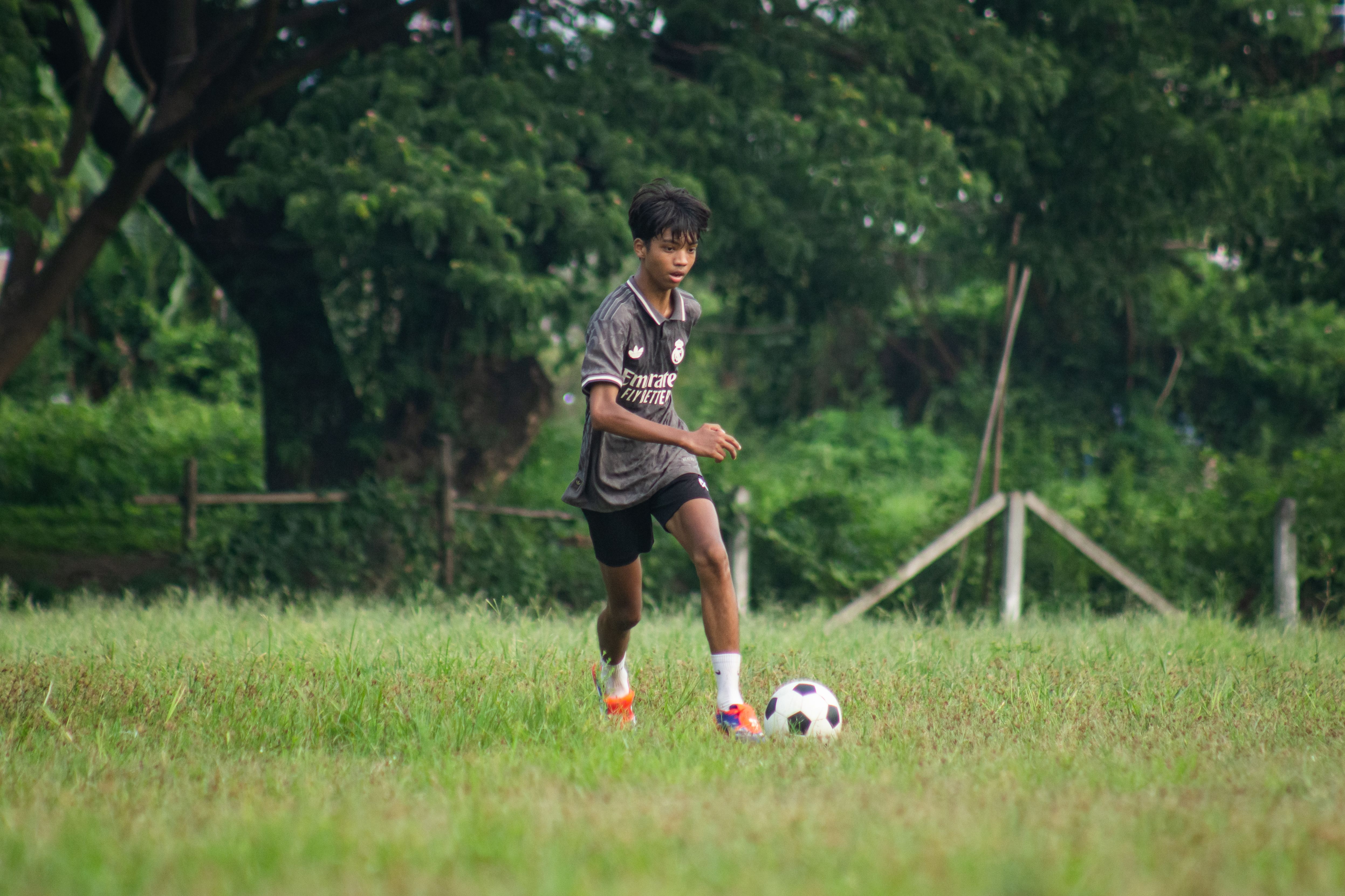 Young Teen Playing Soccer in Myanmar Field
