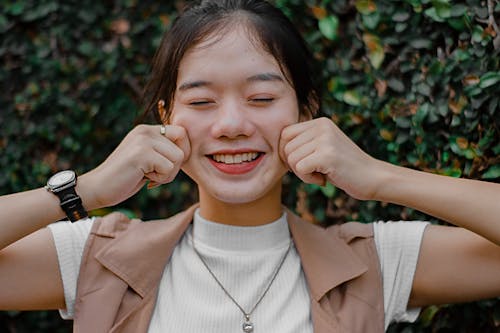 Close-Up Photo of Girl Touching Her Cheeks