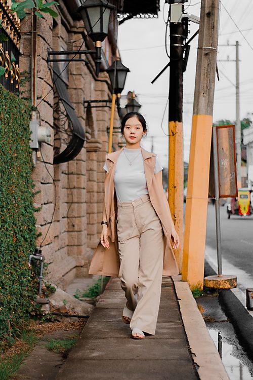 Free Full body of self esteem young Asian female traveler in trendy outfit strolling on narrow sidewalk on city street Stock Photo