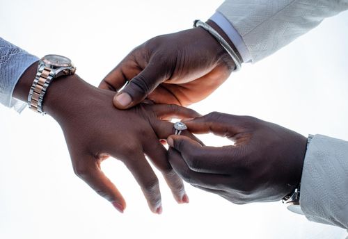 Free Close-up of hands during an elegant engagement ring exchange ceremony. Stock Photo
