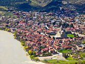 Aerial shot of historic city Mtskheta, showcasing the Svetitskhoveli Cathedral and the surrounding landscape.