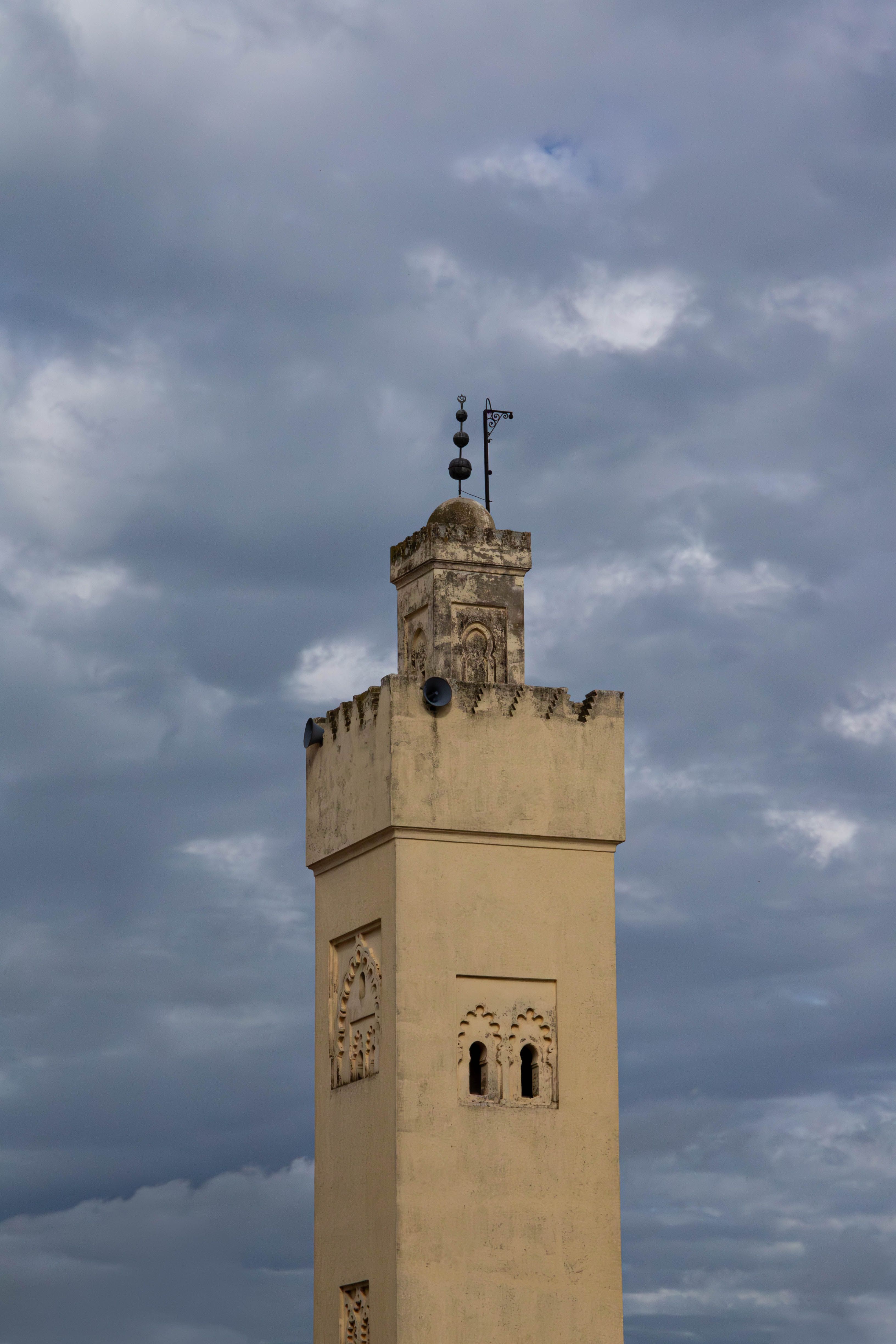 Historic Minaret Tower Against Cloudy Sky in Fes · Free Stock Photo