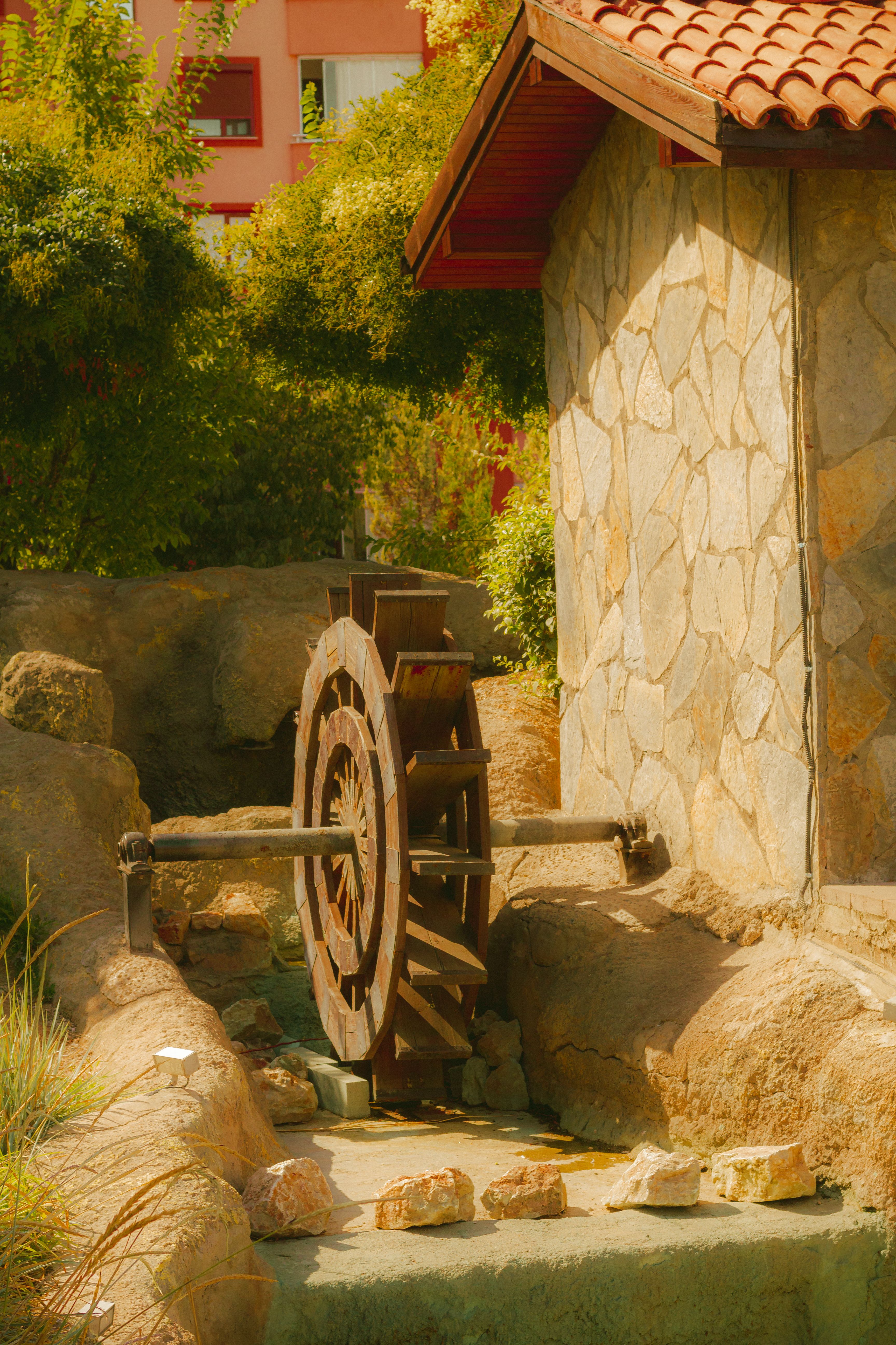 Rustic Water Wheel by Stone Building · Free Stock Photo