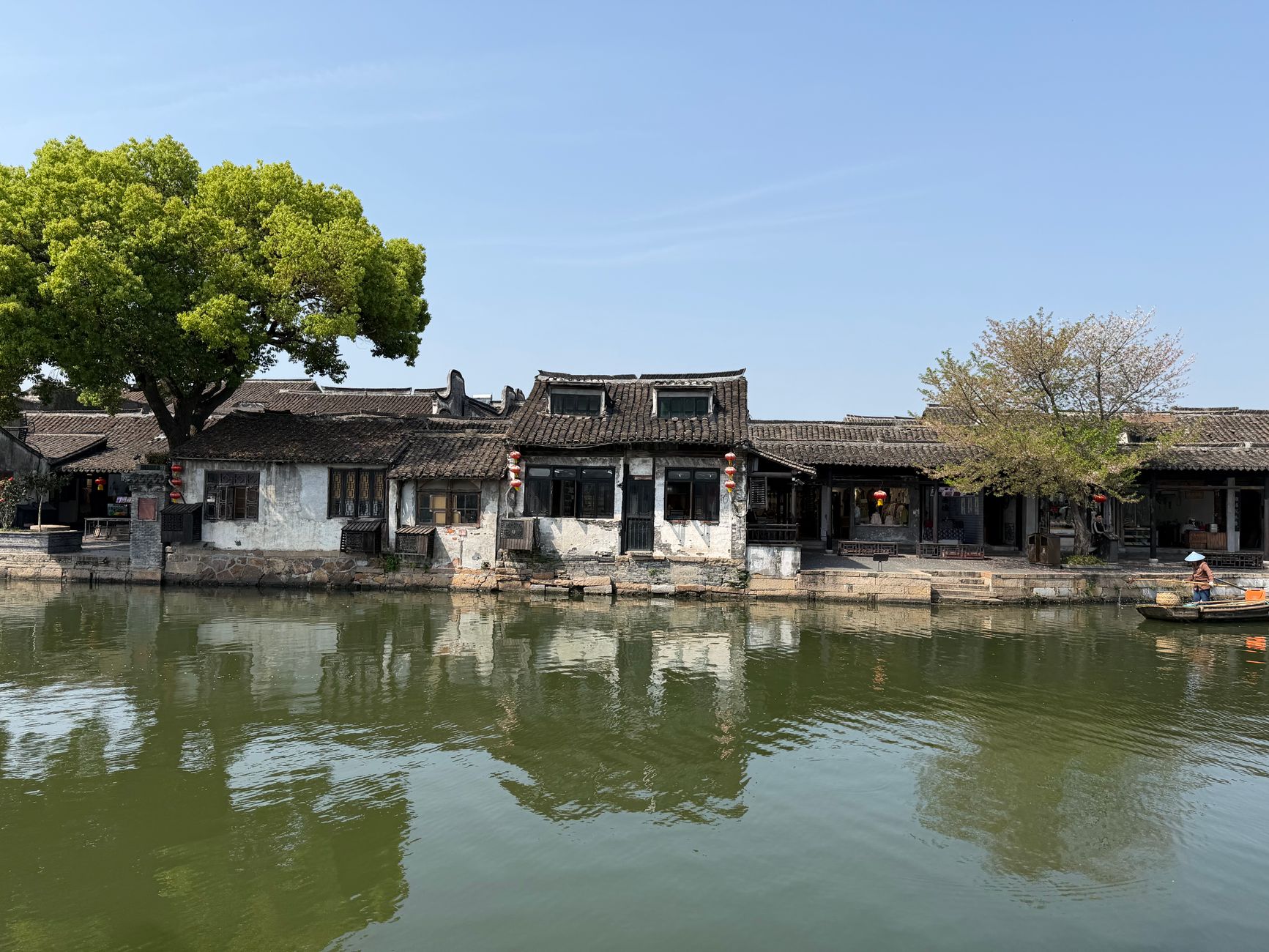Serene view of ancient Chinese buildings reflecting in the tranquil waters of a historical town.