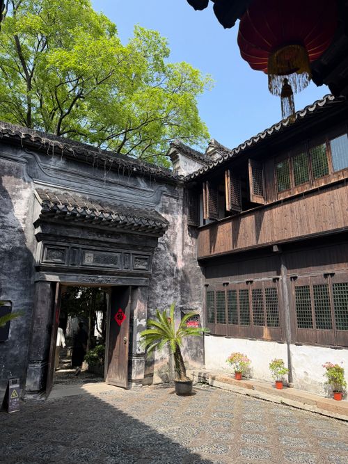 Free Serene traditional Chinese courtyard with lush greenery and historic architecture under a bright sky. Stock Photo