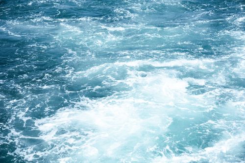 Free A vivid capture of ocean waves crashing with frothy water under bright daylight. Stock Photo