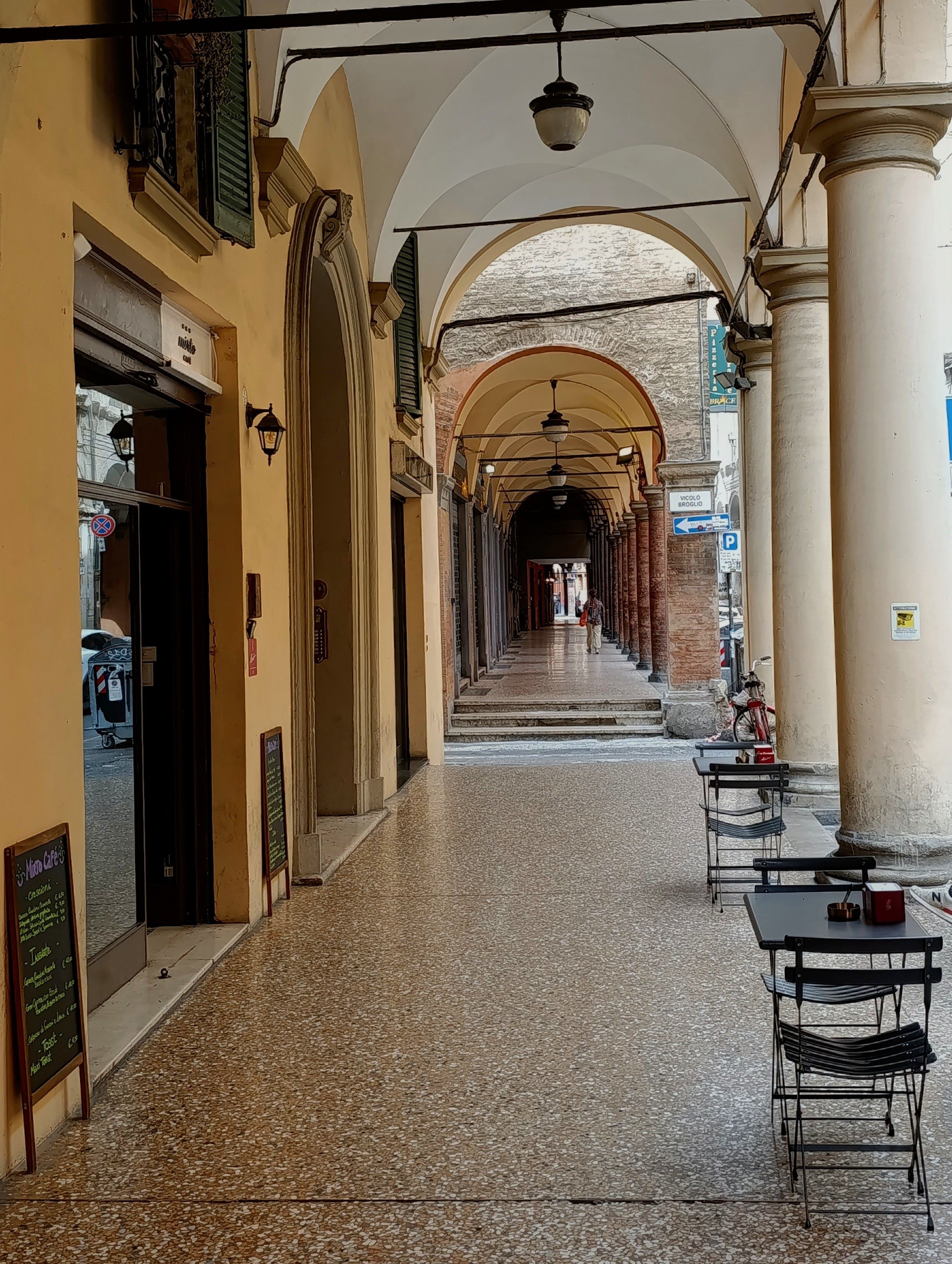 Covered portico walkway with arches and columns in the historic centre of Bologna, Italy