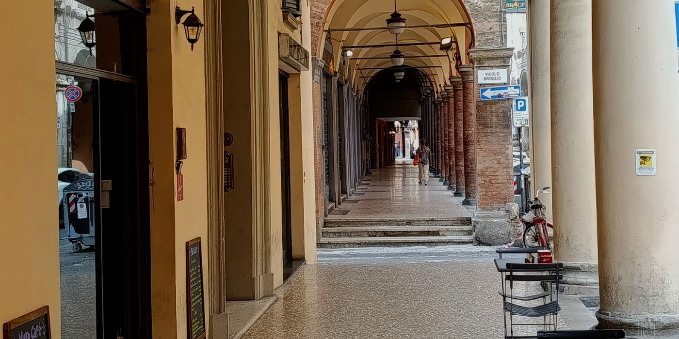 Covered portico walkway with arches and columns in the historic centre of Bologna, Italy
