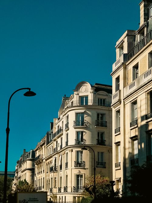 Free Charming Parisian building facades with classic architecture under a clear blue sky. Stock Photo