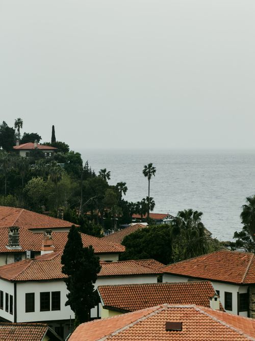 Free Charming coastal view of Antalya's rooftops and sea, capturing serene Mediterranean atmosphere. Stock Photo