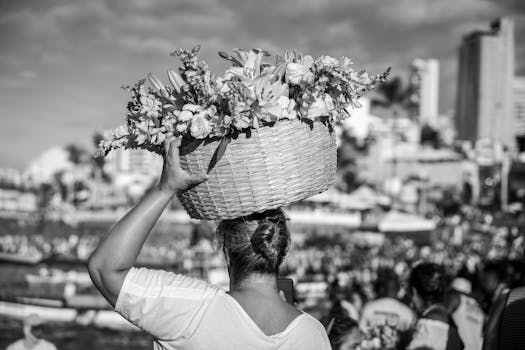 Woman carrying a floral basket on her head in black and white in Salvador, Brazil.