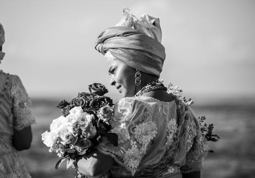Gray Scale Photo of Woman Holding Flower Bouquet
