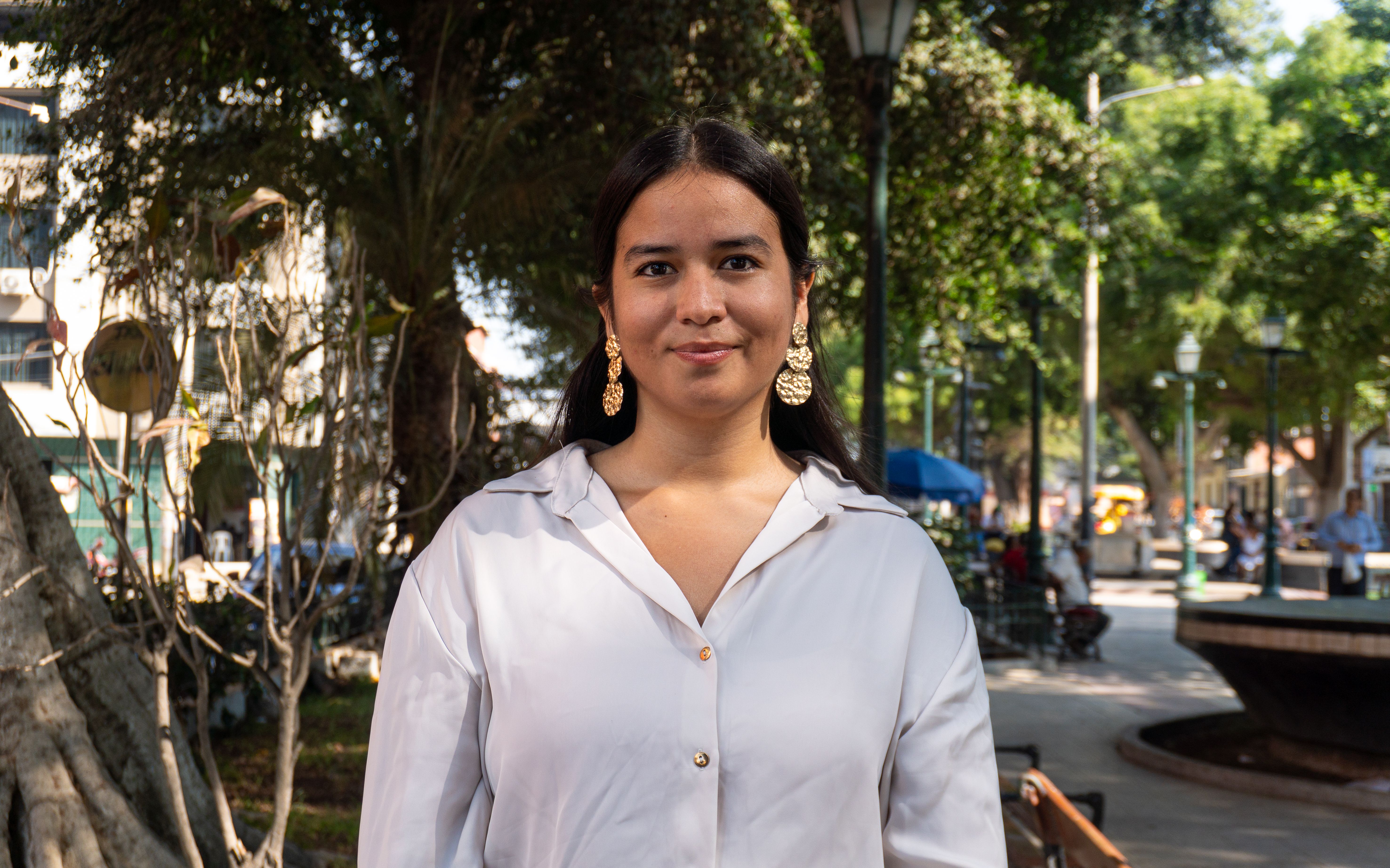 Portrait of a woman in a sunny urban park in Piura, Peru, exuding confidence.
