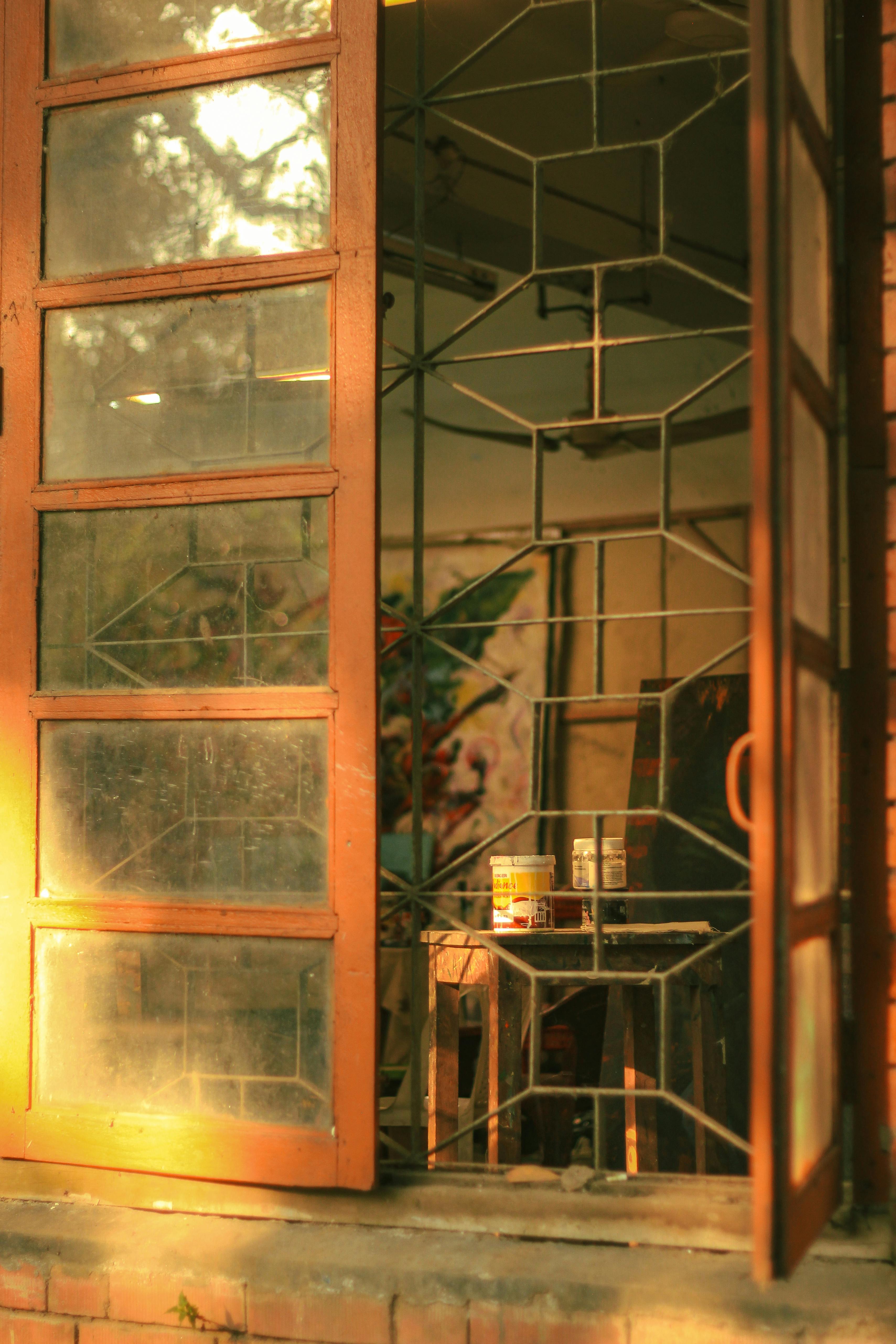 Warm sunlight streaming through a vintage window in an art studio in Dhaka, Bangladesh.