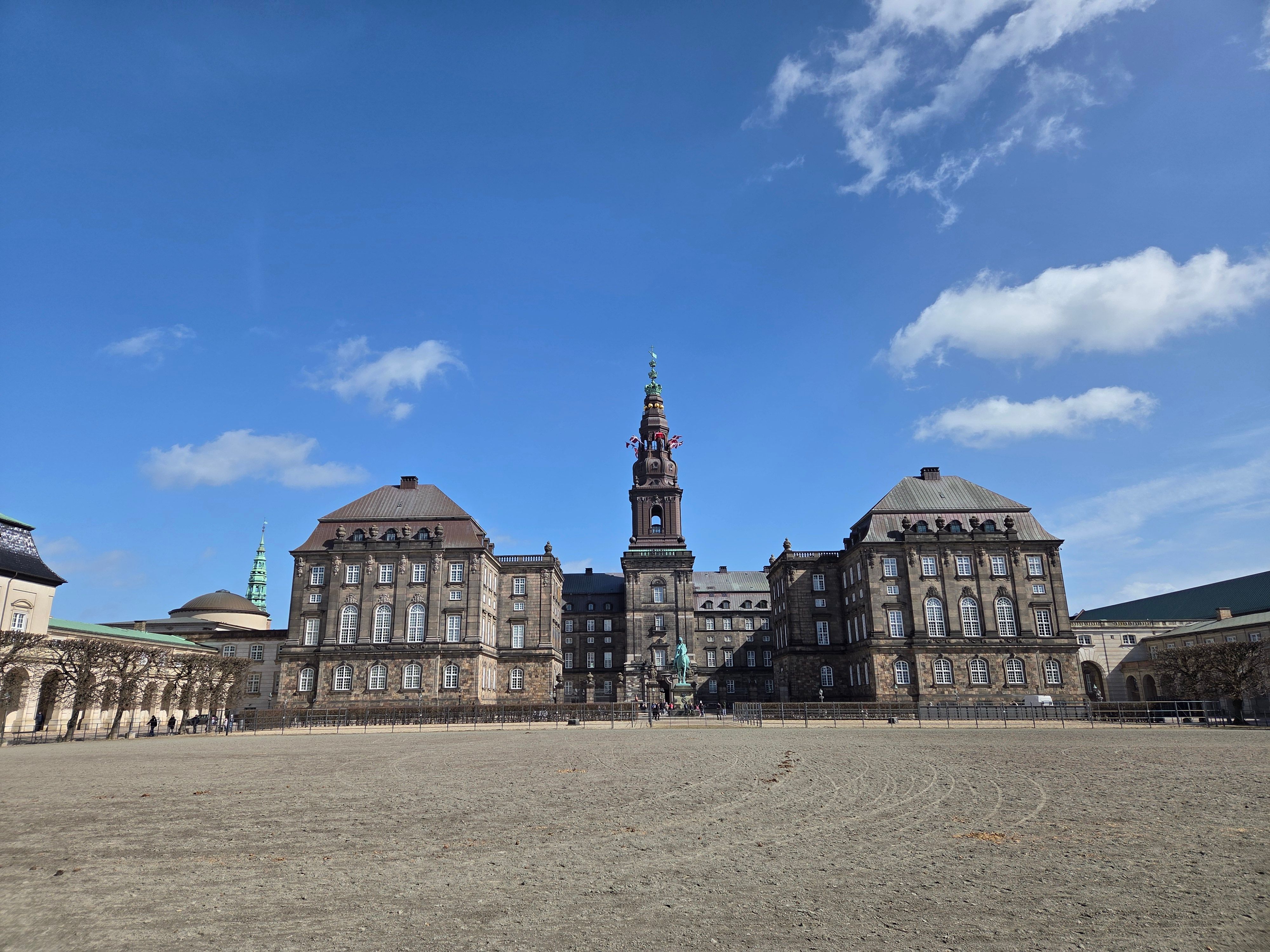 View of Christiansborg Palace under a clear blue sky in central Copenhagen.