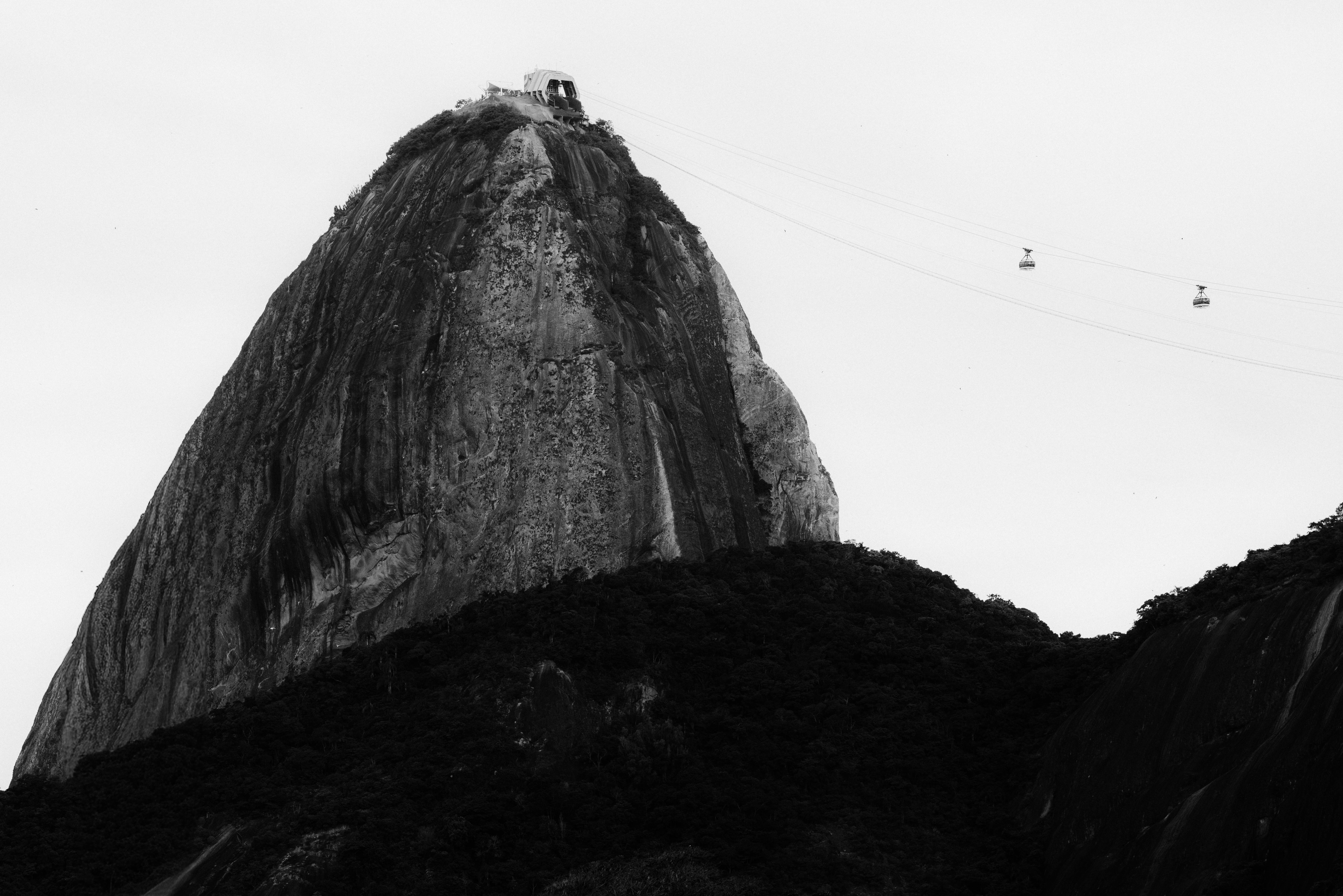 Black and white image of Sugarloaf Mountain and cable cars in Rio de Janeiro, Brazil.