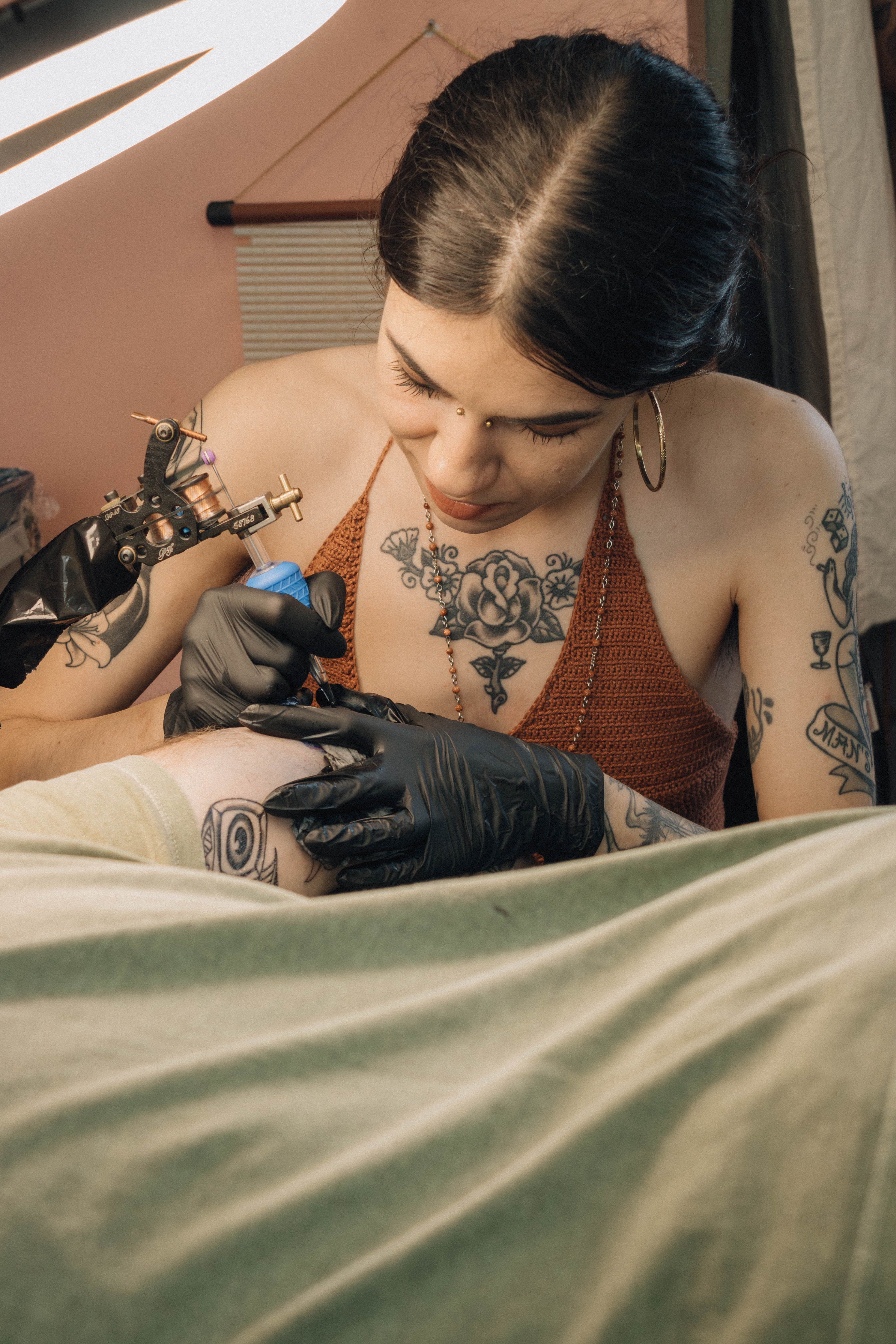 Tattoo artist skillfully creating detailed design on client in studio setting.
