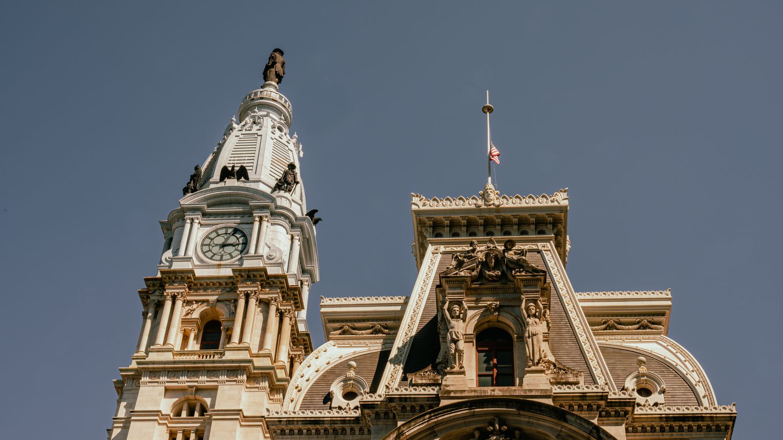 Close-up perspective of the iconic Philadelphia City Hall with its grand clock tower against a clear sky.
