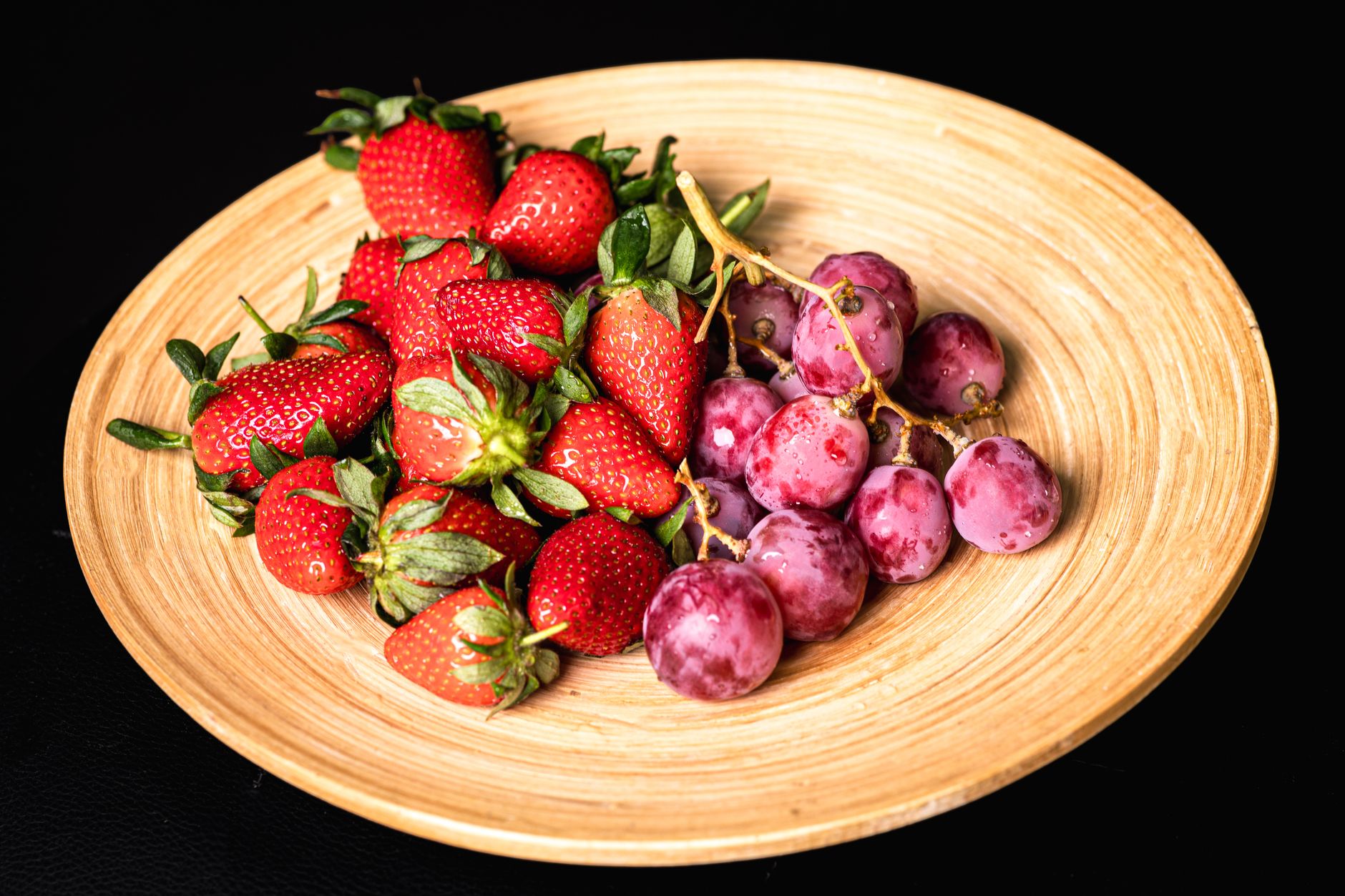 A vibrant display of resveratrol-rich foods including red grapes, blueberries, peanuts, and dark chocolate.