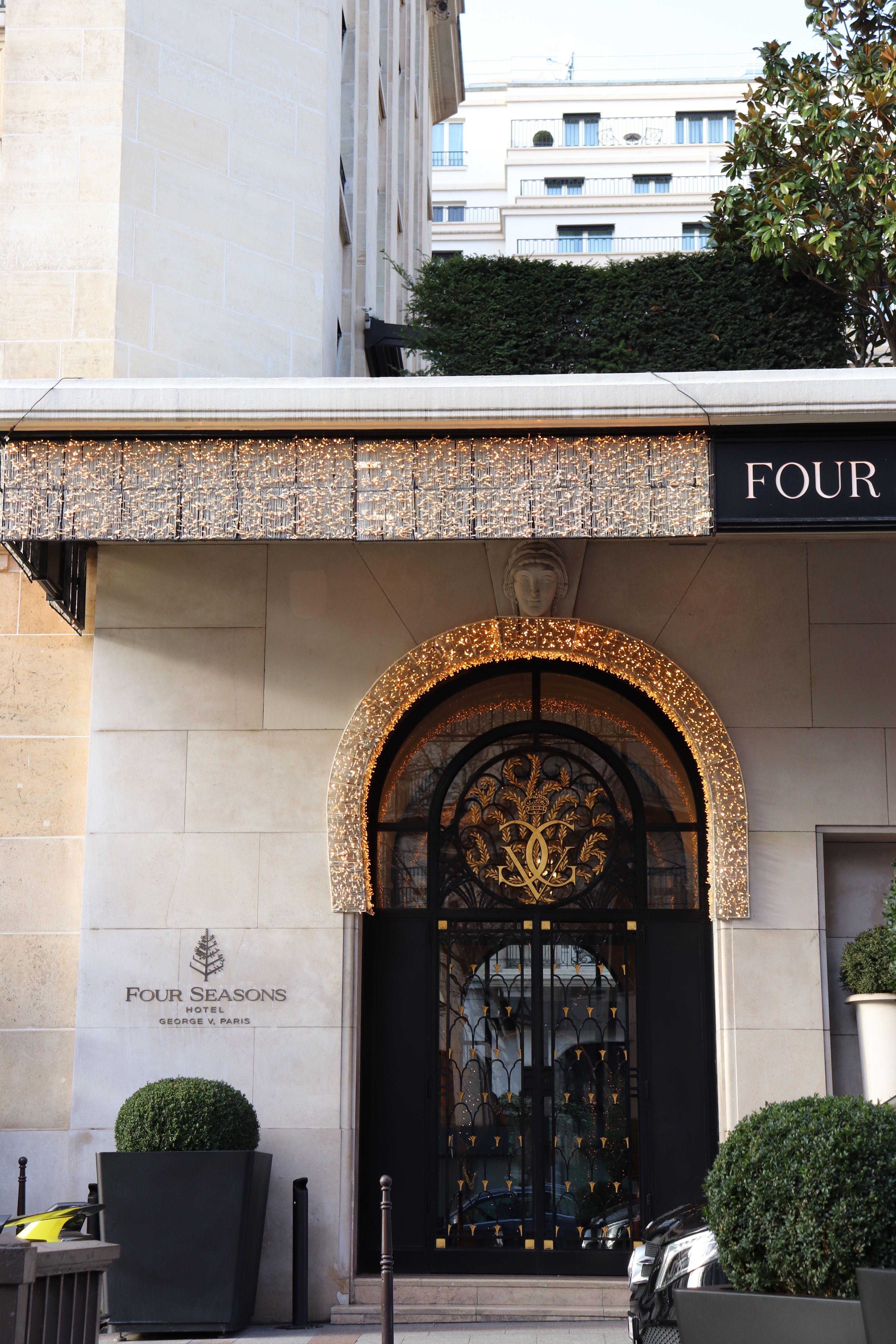 Grand entrance of the Four Seasons Hotel Paris with ornate stone facade and ironwork
