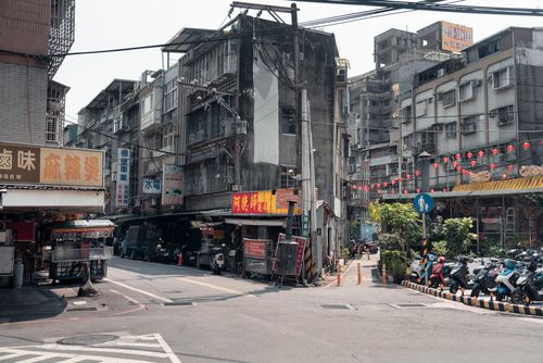 Free Urban street corner in Taipei City with traditional markets and scooters, showcasing daily life. Stock Photo