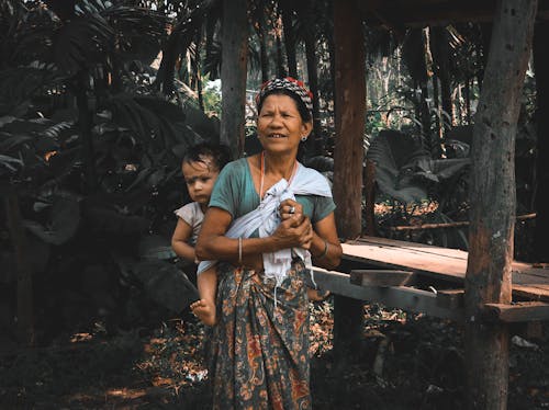 Woman in Blue T-shirt Carrying Baby